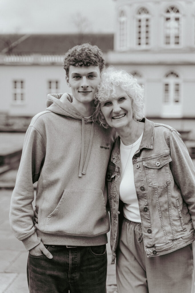 Eine Mutter steht mit ihrem Sohn zusammen und beide lächeln in die Kamera