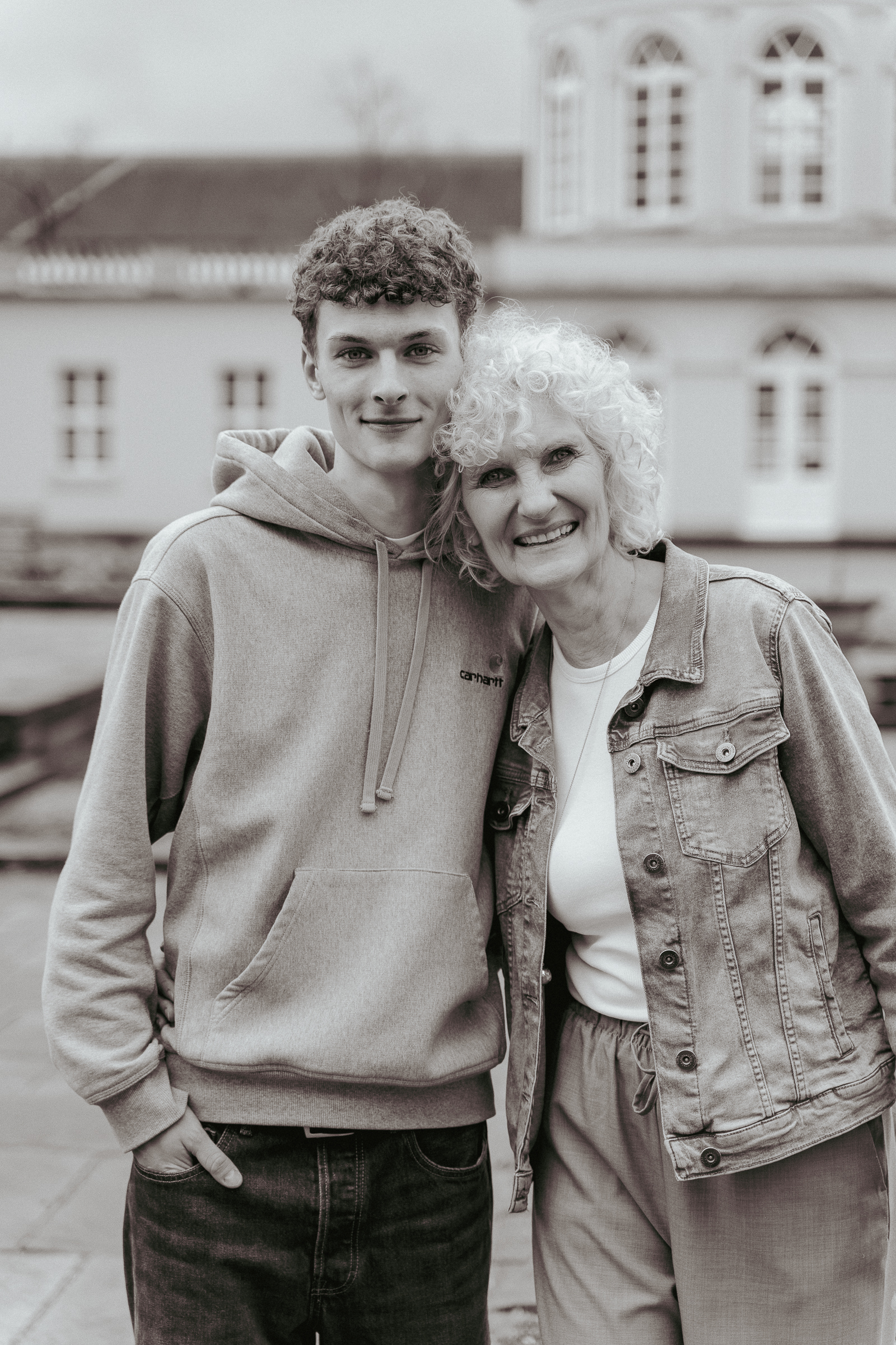 Eine Mutter steht mit ihrem Sohn zusammen und beide lächeln in die Kamera