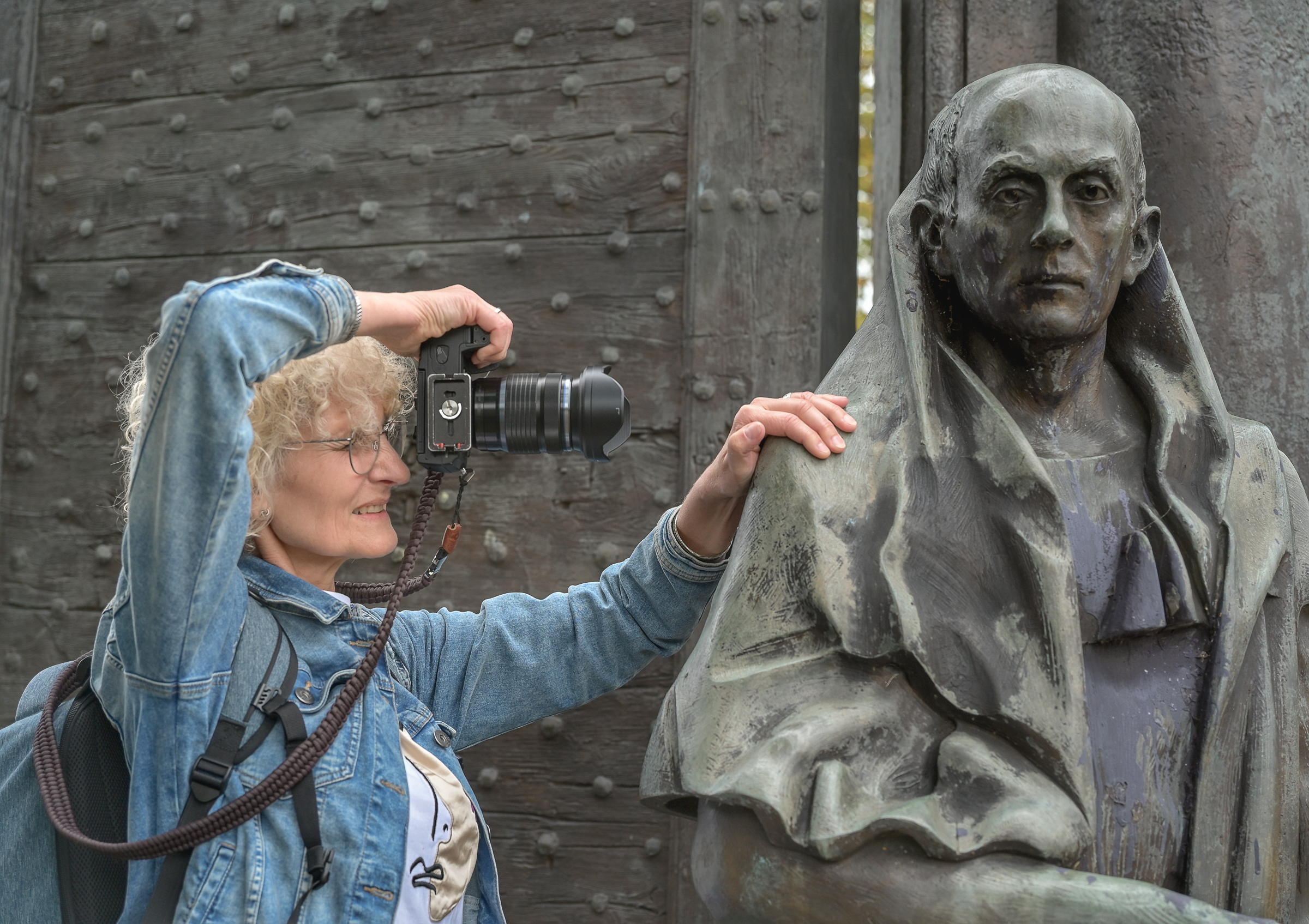 Fotografin fotografiert eine Statue und hat ihre Hand auf dessen Schulter